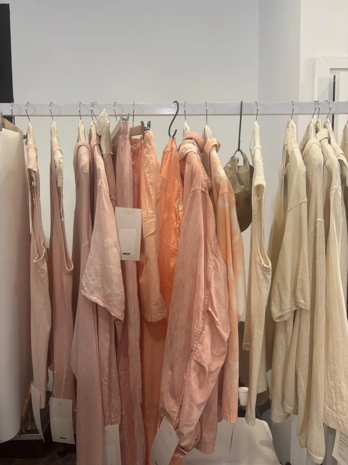 A showroom rail of pale pink, peach and cream garments from the collection.