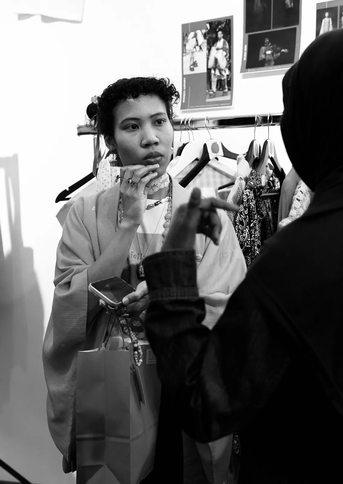 Black-and-white photograph of a conversation with a visitor at a Tanowa Tomiyama presentation.